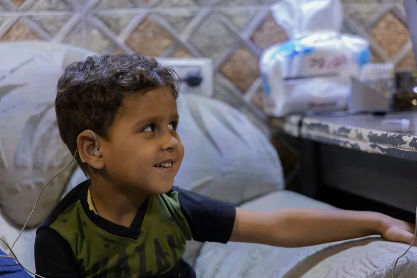 A boy receives a hearing aid for the first time
