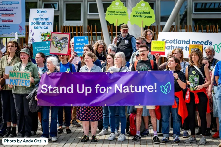 Image taken by Andy Catlin of a group of people holding up banners including a large central one saying 'Stand Up for Nature!'