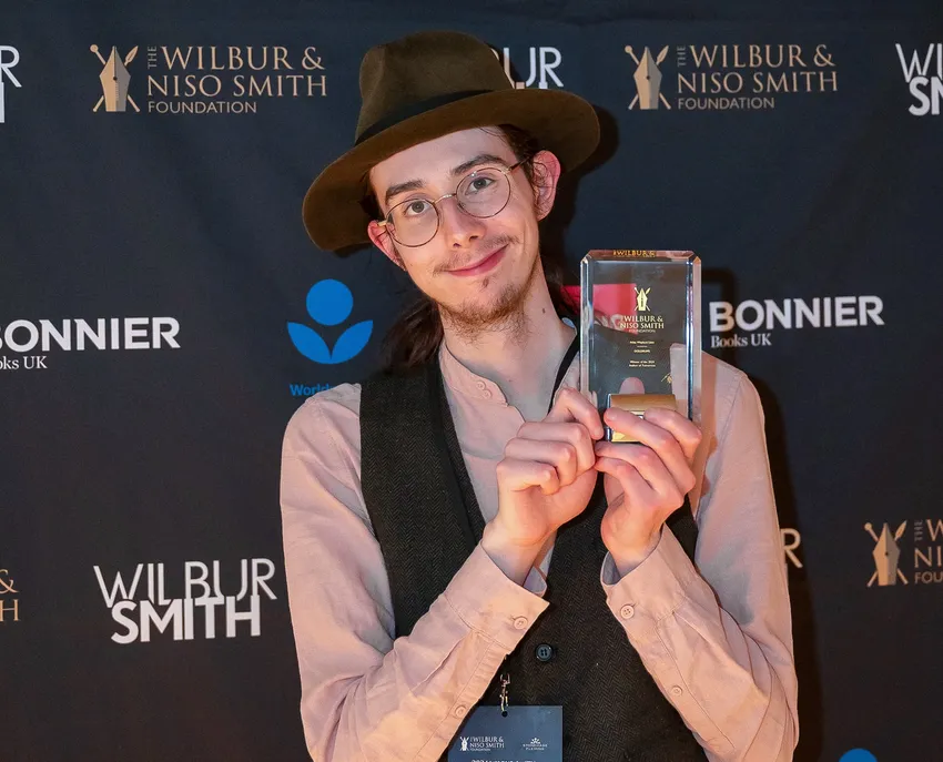 A young writer accepting his trophy for winning the Author of Tomorrow award before returning as a young judge.