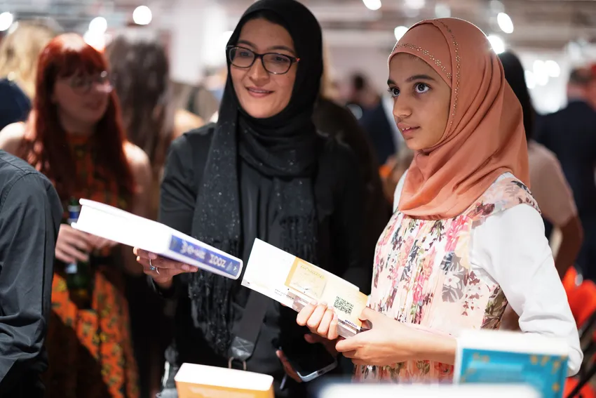 A young writer and her Mother looking at books after winning an Author of Tomorrow award.