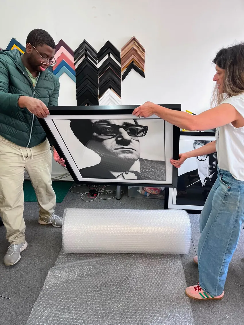 Teacher Debs and her trainee show one of their newly framed pictures