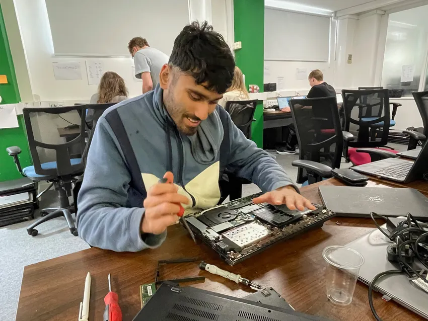 A 2econd Chance trainee works on repairing and refurbishing a laptop