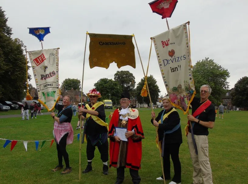 Community supporters of the Assize Court Project standing on the green with banners celebrating it.