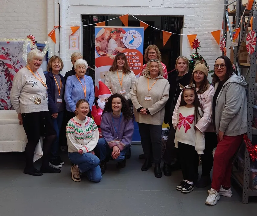 The Pelican Parcels team smiling in the warehouse with Christmas decorations