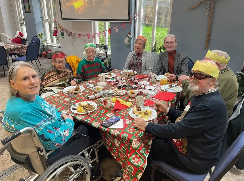 People enjoying Christmas dinner around a table