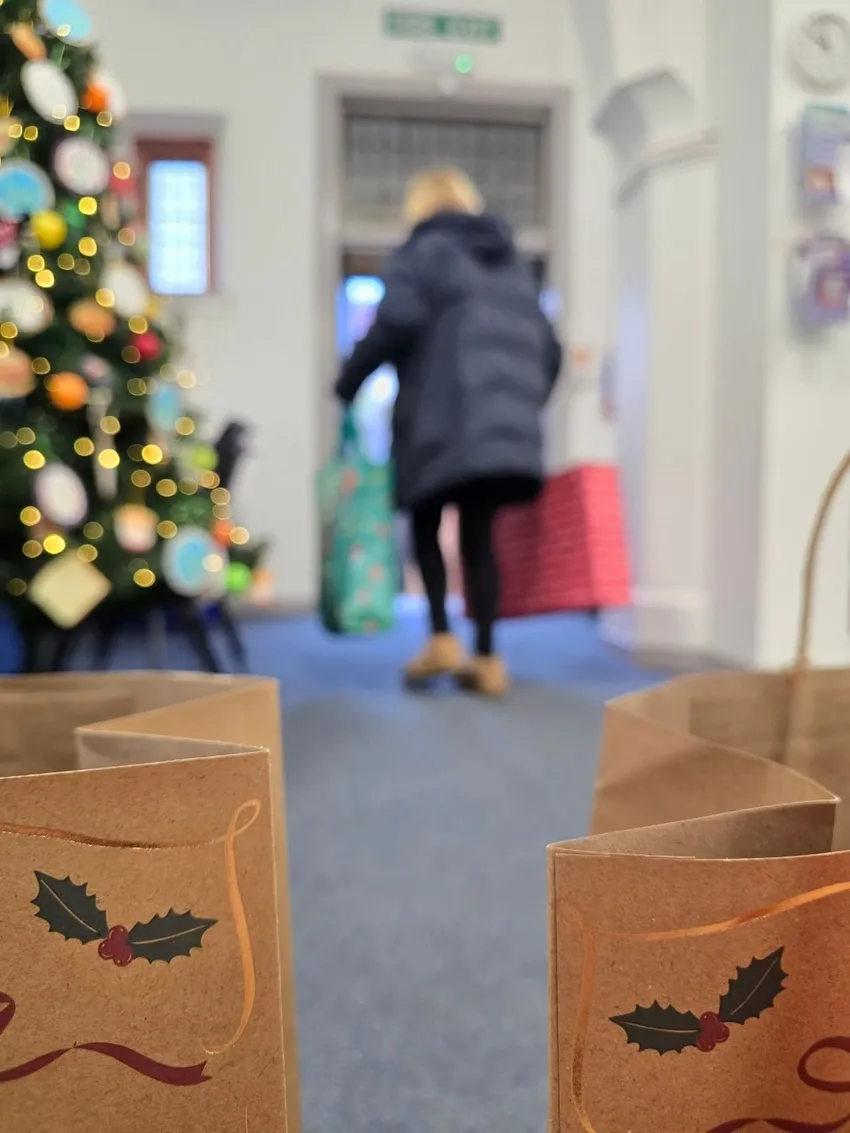 Client leaving food bank with Christmas giftstaff